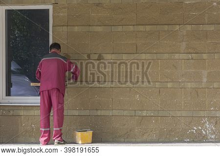 Russia, Bryansk-07/23/2018: A Worker Plasters The Wall Of A Building. Stock Photo.