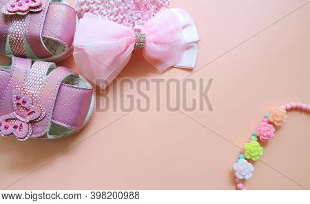Pink Girl's Bow And Beads On Pastel  Pink  Background,    Children's Flat Lay. Children's Jewelry An