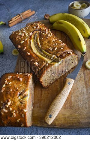 Wholegrain Banana Bread Freshly Sliced On A Cutting Board, With Banana, Cinnamon And Nuts. Bake Shop