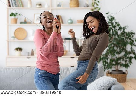 Carefree African American Girlfriends Singing And Dancing, Having Fun Together At Home, Copy Space. 