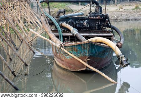 Old Dredger Bounded Beside The Bamboo Bridge On A Small River In Bangladesh