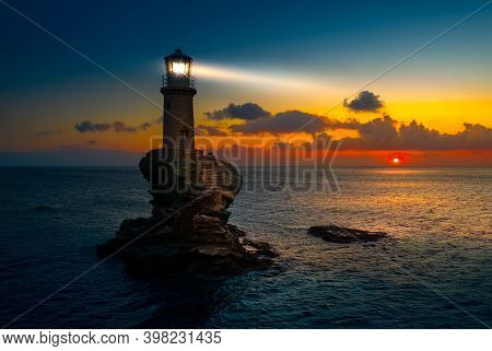 The Beautiful Lighthouse Tourlitis Of Chora At Night. Andros Island, Cyclades, Greece