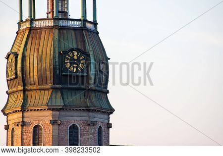 Symbol Of Riga, Old Clock On Medieval Church Tower Among Roofs Ancient Buildings With European Archi