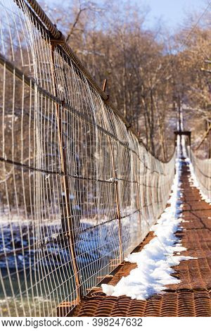 Suspention Bridge Over The Mountain River Winter View.