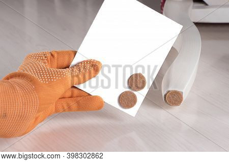 Anti-skid Felt Pad Cover Sticking On Wooden Furniture Leg. Hand Holding Set Floor Care Pad. Adhesive