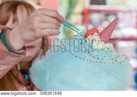 Child Eating Sweets And Candy On A Huge Cotton Candy Floss With Ice Cream And Dessert Sauce