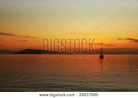Tramonto sopra Angistri (a sinistra) e le montagne del Peloponneso, in Grecia, con un moo di yacht