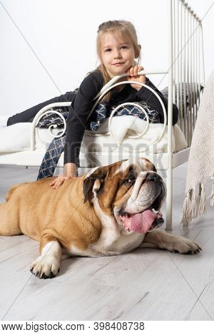 In The Girls Bedroom There Is An English Bulldog Next To Her Bed And The Child Is Lying On The Bed A