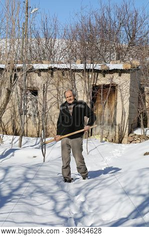 Nigde,turkey-january 15:old Turkish Farmer  Posing With Pickaxe In Snow In Nigde,turkey