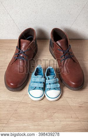 Mens And Childrens Shoes On A Wooden Floo