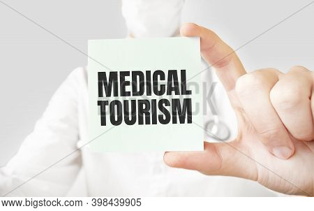 Doctor Holding Card In Hands And Pointing The Word Medical Toursim