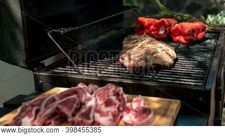 Chef Cooking A Delicious Pork Ribs With Red Peppers On Bbq Grill Garden. Spain