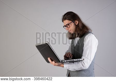 Programming And Writing Code, Developing Software Products. Geek Guy, With Long Hair And Glasses, Ho