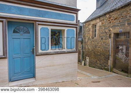 Morlaix, France - August 28, 2019: Blue Door And Wooden Shutters On The House With Flowers In The Ol