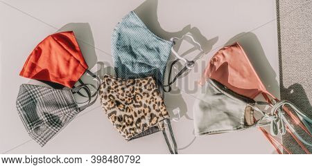 Fashion face masks top view banner. Panoramic crop of many mouth covering. Coronavirus trend of DIY sewing mask at home in different colors and styles, patterns and fabrics.
