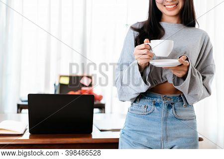 Woman Relxing Time While Working And Hold Cup Of Coffee At Working Place.