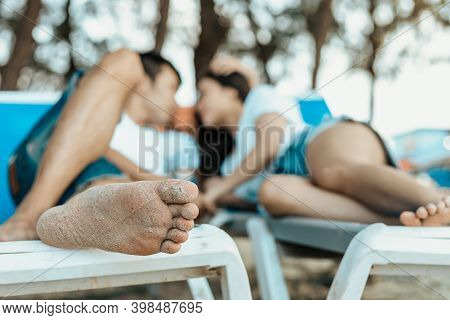 Couple Sitting On The Deck Chairs At The Beach. Honymoon, Love, Travel Or Vacation Concept.