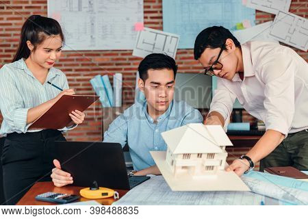 Businessman And Architech Meeting For Planing And Checking House Design And House Model And Secretar