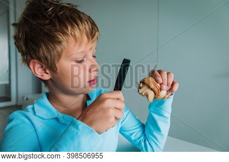 Boy Looking At Giant Snail Through Magnifiying Glass