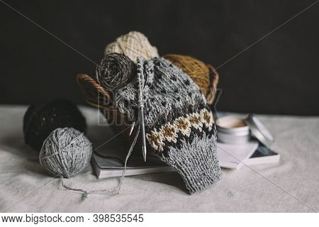 Hand Knitting With Needles And Yarn Balls In A Basket On A Dark Background. Concept For Handmade And