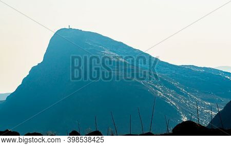 Mount Bitihorn In Norway At A Distance With Blurry White Haze In The Background.