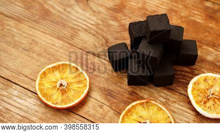 Coals For Hookah On Wooden Background With Dry Oranges