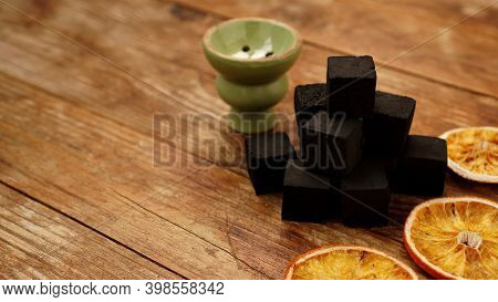 Coals For Hookah On Wooden Background With Dry Oranges And Bowl. Place For Text