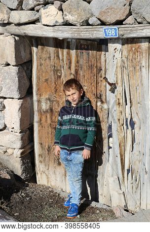 Nigde,turkey-january 15:unidentified Boy Standing By The Old Wooden Door.january 15,2017 In Nigde,tu