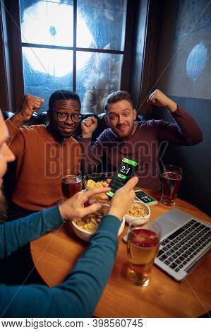 Astonished. Excited Fans In Bar With Beer And Mobile App For Betting, Score On Their Devices. Screen