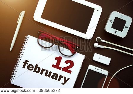 February 12nd. Day 12 Of Month, Calendar Date. Office Workplace With Laptop, Notebook, Office Suppli