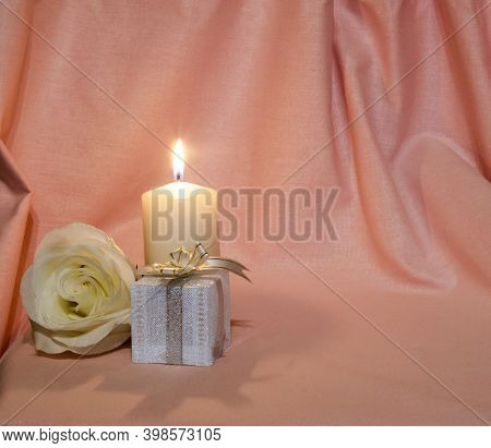 Congratulations On The Holiday. Postcard With Candles And A Rose On A Pink And White Background
