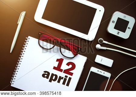 April 12nd. Day 12 Of Month, Calendar Date. Office Workplace With Laptop, Notebook, Office Supplies 
