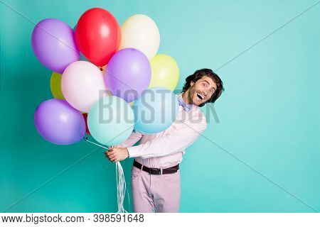 Photo Of Amazed Young Guy Hold Colorful Hellium Balloons Isolated On Turquoise Color Background