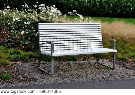 Benches With Metallic Shiny Stainless Steel Construction, Armrests, White Wood Paneling In Public Pa