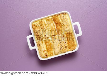 Top View With French Pancakes Rolls Stuffed With Curd Cheese Baked In A Tray With Sweet Cream Sauce.