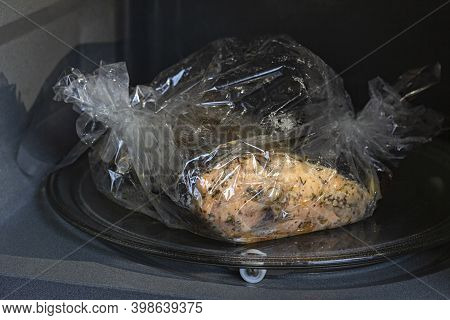Spiced Fresh Trout Fish Wrapped In A Baking Sleeve In A Microvawe Oven, Cooked, Closeup View
