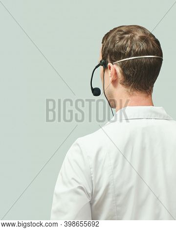 Male Doctor With Headphones. Studio Medicine Portrait. Clinic Online Help. Health Support Call. Tele