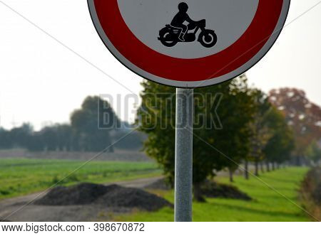 Road Sign No Entry Of All Motor Vehicles, Including Motorcycles Is Located In The Fields By The Road
