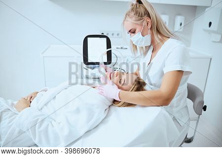 Pleased Young Patient Receiving The Microneedling Treatment