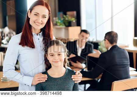 Joyful Red-haired Woman Is Standing In Foreground And Hugging Joyful Girl In Lawyer's Office.