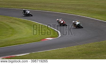 A Shot Of Several Racing Bikes Cornering On A Track.