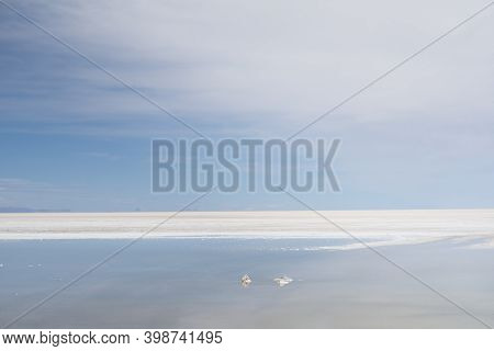 Tranquille Landscape At Salar De Uyuni With Soft Clouds And Reflections In The Water