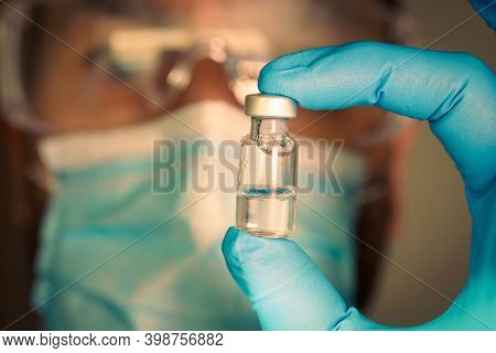 Close-up Of Medical Vial With Blurred Doctor On The Background.