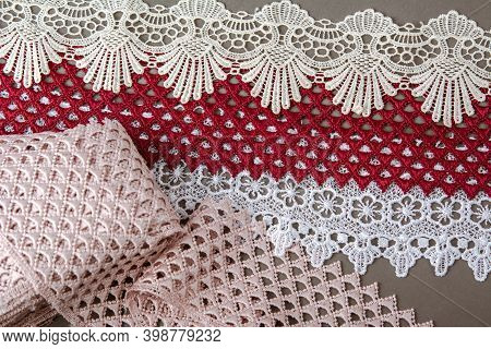 Pile Of Red, White. Beige Set Sail Champagne Gentle Luxury Quality Guipure, Lace Fabric On Gray Back