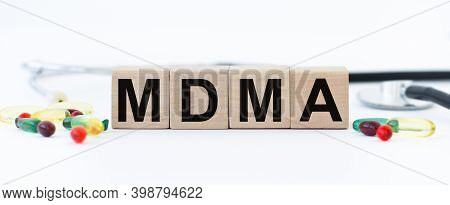 Cubes With The Word Mdma On Them Near A Stethoscope And Scattered Pills On A White Background. Care 