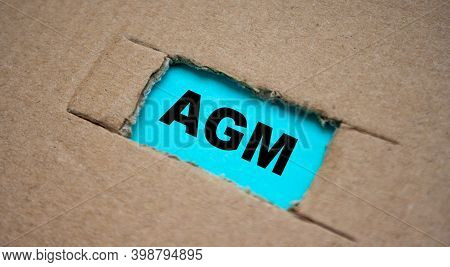 A Cut-out Hole In The Paper Cardboard, And Under It A Piece Of Paper With The Word Agm. The Word Agm