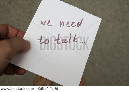 Woman Holding A Piece Of Paper With Hand Written Frase, Message We Need To Talk, Communication Probl
