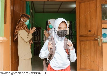 Portrait Of Students Saying Goodbye To Teachers With Social Distancing Protocols