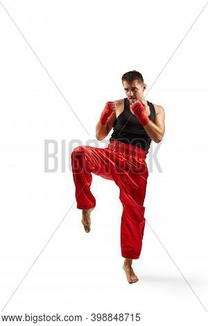 Athletic Man In Red Sports Bandages On His Hands Making Kick During Boxing Exercise, Isolated On Whi