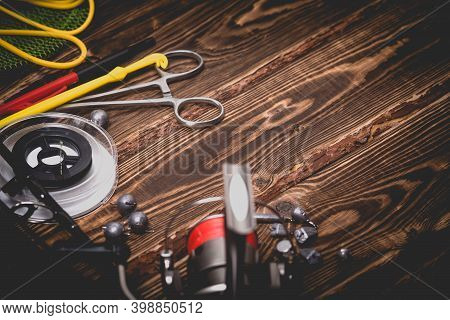 Fishing Tackle On A Wooden Background. Studio Photo With Vignetting.